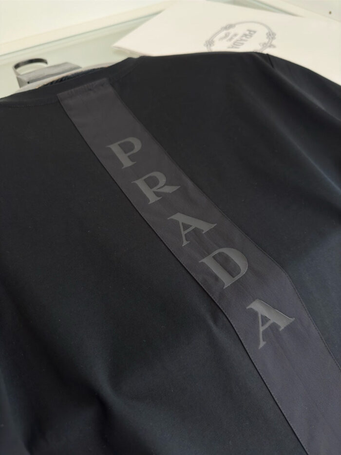 Maglietta nera Prada con logo lucido sulla schiena, stile moderno e di lusso.