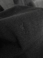 Logo Yves Saint Laurent su tessuto nero lussuoso con dettaglio ricamato sottile.
