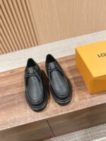 Scarpe nere di lusso con scatola gialla, stile elegante e qualità artigianale in dettaglio.