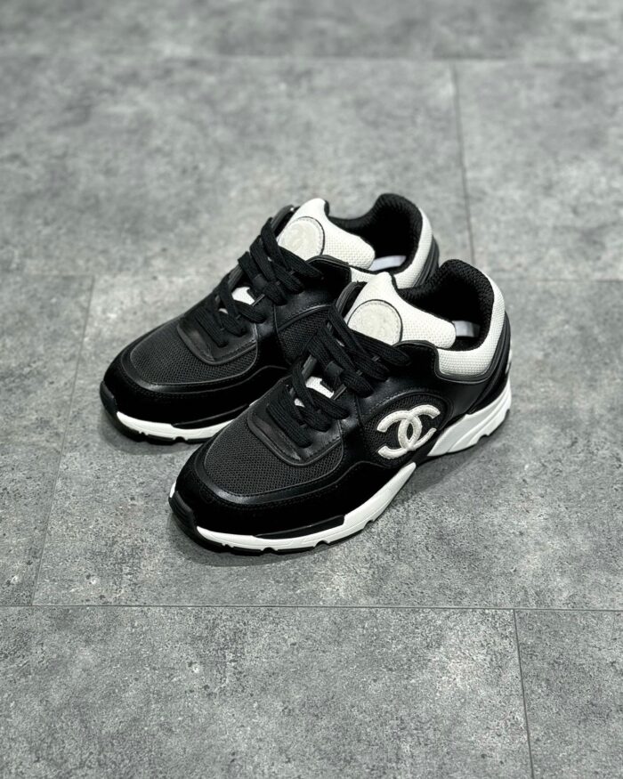 Sneaker nere di lusso con logo iconico, design sportivo e suola robusta, stile elegante e moderno.