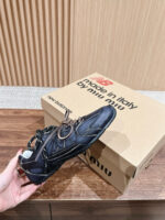 Scarpa Miu Miu nera elegante con charm metallico, su tavolo in legno, stile moderno e sofisticato.