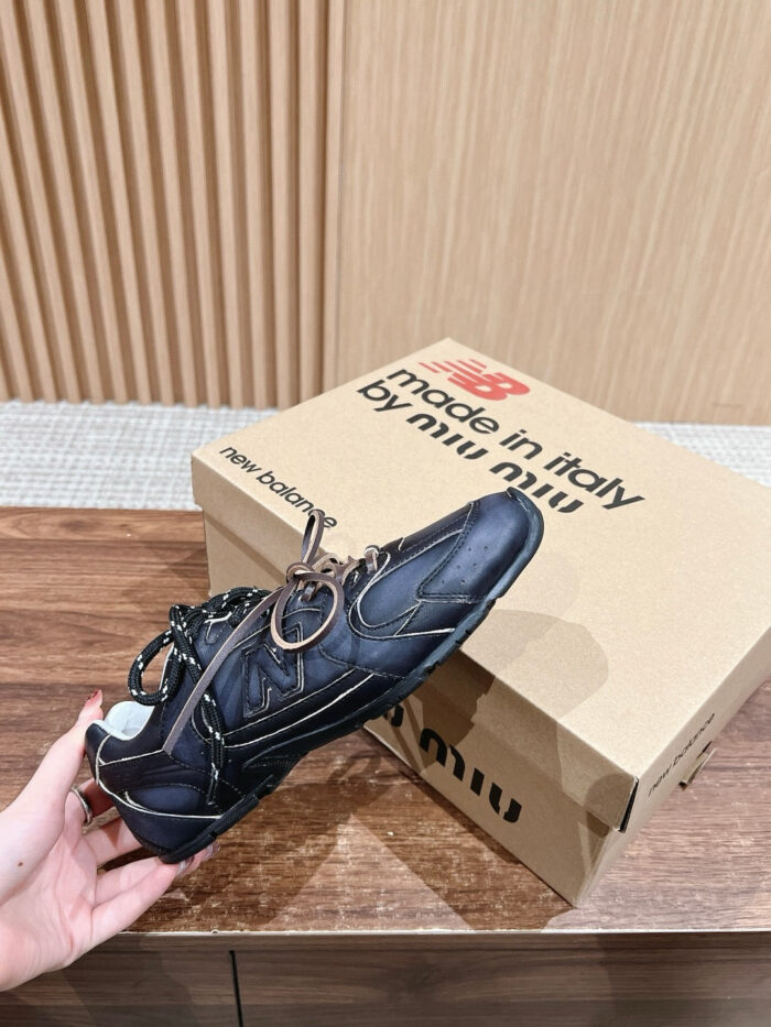 Scarpa Miu Miu nera elegante con charm metallico, su tavolo in legno, stile moderno e sofisticato.