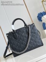 Borsa nera elegante con dettagli in metallo e motivi iconici, stile moderno e raffinato.