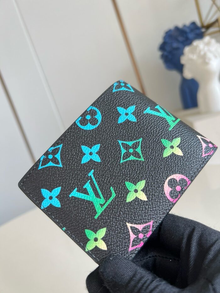 Portafoglio di lusso nero con motivi floreali colorati e logo iconico italiano.