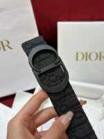 Bracciale Dior nero con fibbia circolare, elegante packaging di lusso, accessorio moda sofisticato.