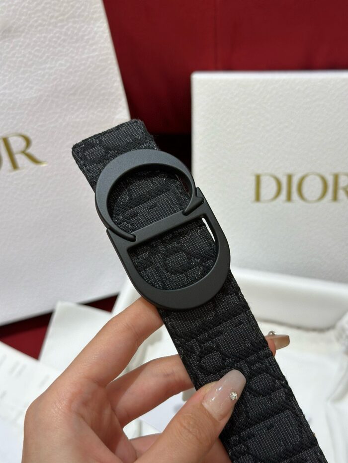 Bracciale Dior nero con fibbia circolare, elegante packaging di lusso, accessorio moda sofisticato.