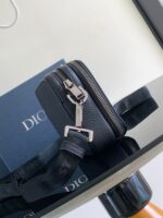 Borsa nera di lusso con scatola Dior e dettagli eleganti su superficie riflettente