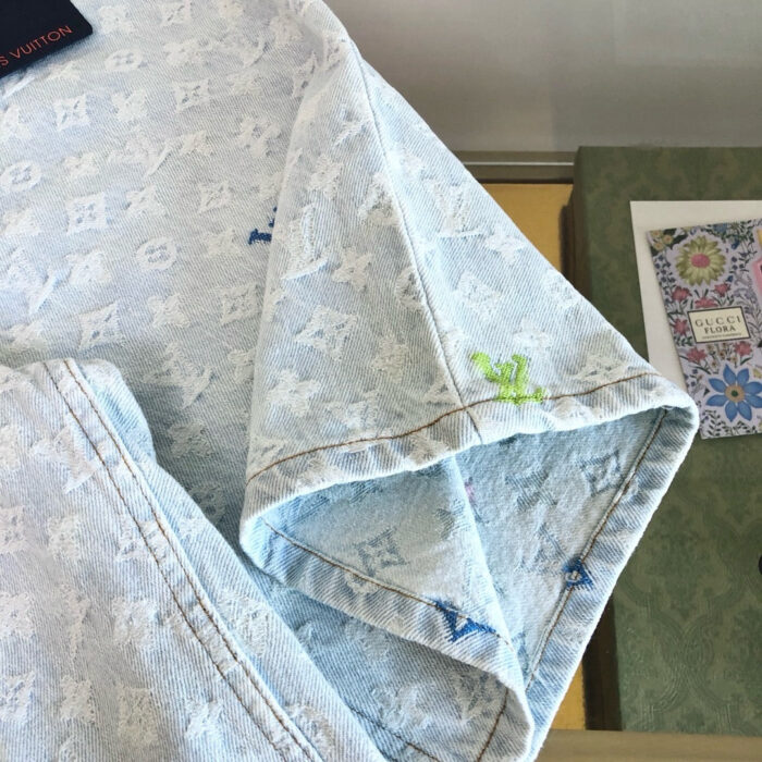 Tessuto denim blu chiaro con ricami colorati e dettagli di alta moda di lusso.