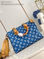 Borsa blu di lusso con logo classico, pom-pom bianco e dettagli eleganti in stile sofisticato.