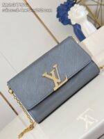 Borsa Louis Vuitton blu con logo dorato e cinturino a catena elegante.