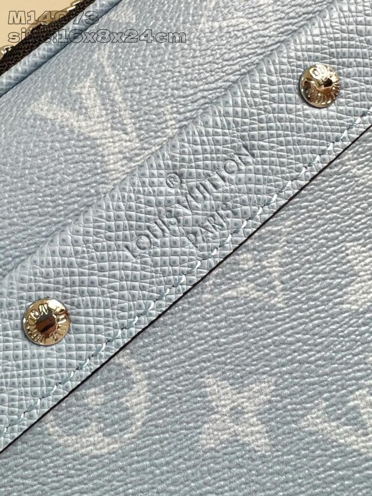 Dettaglio di borsa Louis Vuitton blu con monogramma, hardware dorato e finiture di alta qualità.