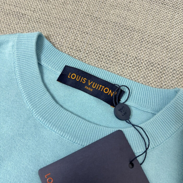 Maglione blu Louis Vuitton con etichetta di lusso e dettagli eleganti.