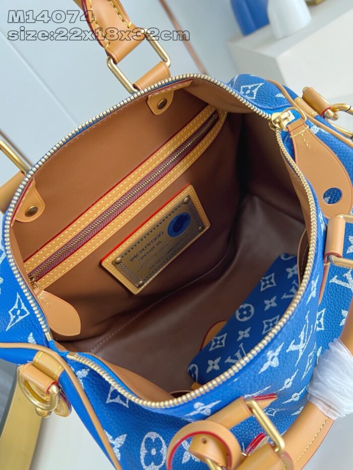 Borsa di lusso blu con interno organizzato, motivi iconici e finiture di alta qualità.