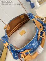 Borsa di lusso blu con logo iconico, dettagli in pelle tan e hardware dorato elegante.