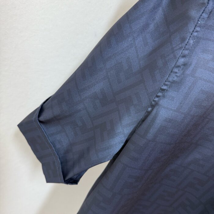Camicia di lusso grigia con motivo branding, dettaglio manica elegante e tessuto satinato.