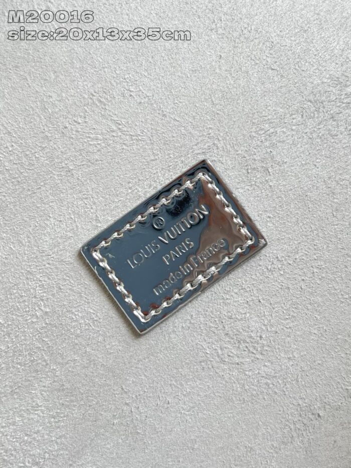 Tag in metallo Louis Vuitton, simbolo di lusso ed eleganza, dettagli raffinati e qualità premium.