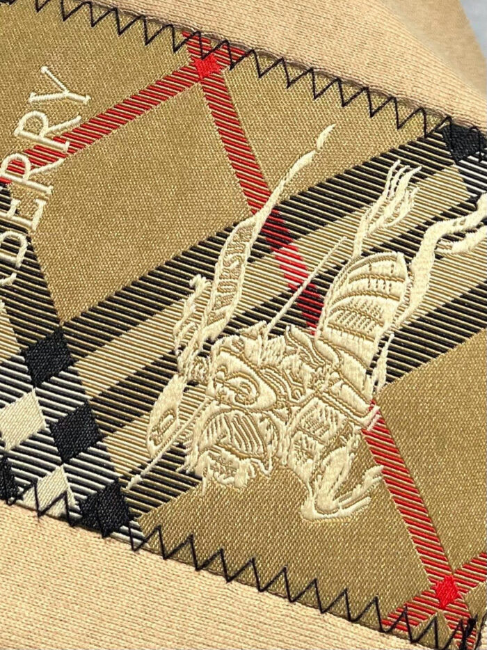 Tessuto Burberry con ricamo di guerriero e pattern checkered nero, rosso e beige, elegante e di lusso.