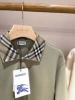 Polo Burberry verde oliva con colletto check tartan e dettagli di lusso raffinato.