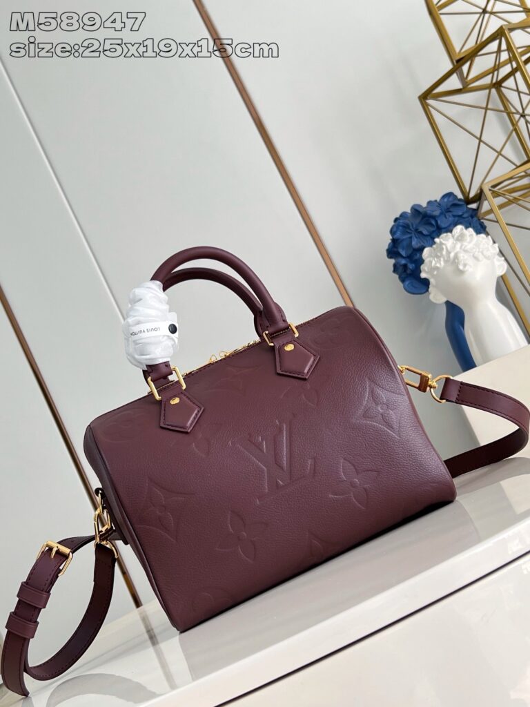 Borsa Louis Vuitton in pelle burgundy con dettagli dorati e decorazioni artistiche eleganti.