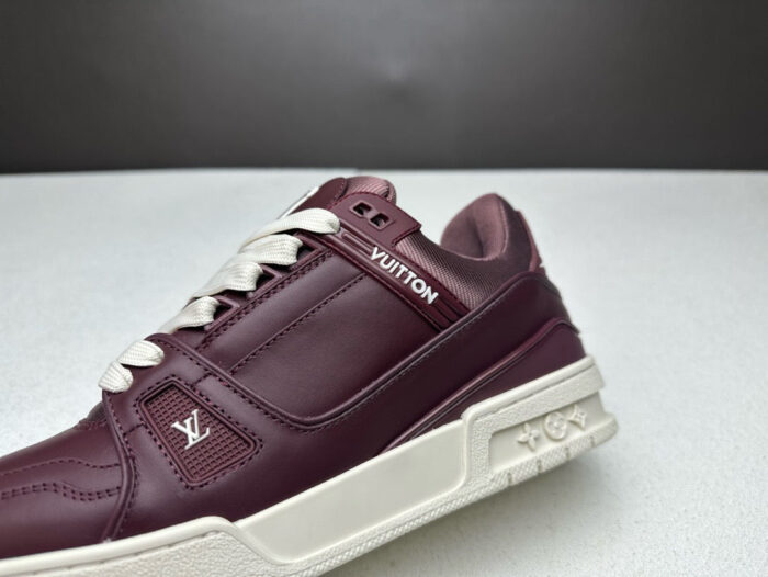 Sneaker elegante burgundy in pelle con logo Louis Vuitton e suola bianca sportiva.