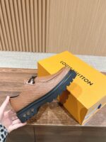 Sneaker di lusso in pelle caramello con suola nera e box giallo brillante, stile elegante.