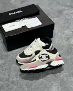 Scarpe Chanel di lusso beige e rosa con design moderno e packaging elegante.