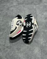 Sneakers Chanel di lusso beige, nero e rosa, stile moderno e design elegante.
