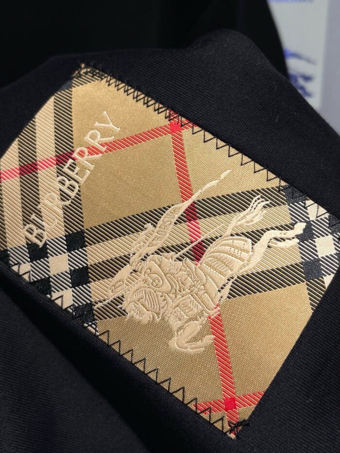 Etichetta di moda checkered con ricamo dorato cavallo e nome BIRBERRY, stile elegante e artigianale.