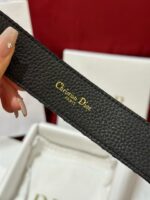 Cintura in pelle nera Dior con logo dorato, packaging elegante e dettagli di alta qualità.