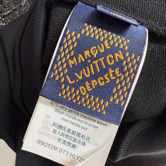 Etichetta di lusso Louis Vuitton con istruzioni di lavaggio e codice di riferimento.