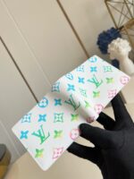 Portafoglio Louis Vuitton colorato con monogramma, elegante e moderno, in mano a guanto nero.