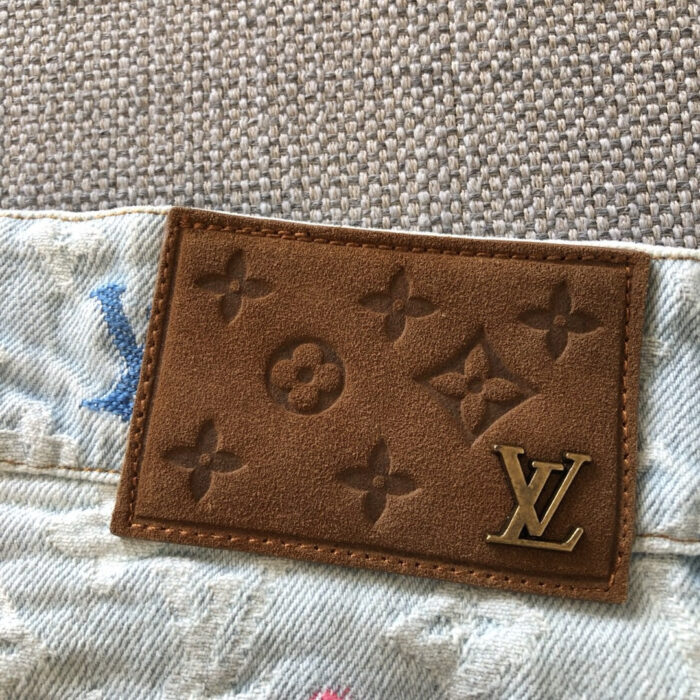 Etichetta Louis Vuitton su jeans in denim di lusso, dettagli di alta qualità e stile casual elegante.