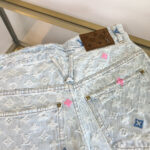 Shorts in denim di lusso con logo in pelle e dettagli colorati vivaci.