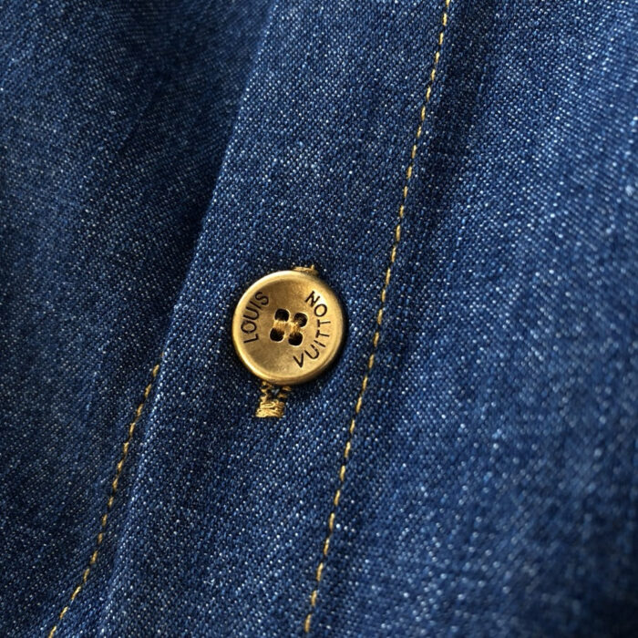 Jeans Louis Vuitton in denim blu con bottone dorato e cuciture gialle di alta qualità.