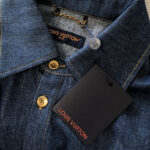 Camicia in denim Louis Vuitton con bottoni dorati e dettagli di lusso elegante.