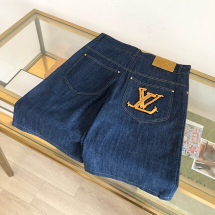Pantaloncini in jeans Louis Vuitton con logo giallo e dettagli di moda di lusso.