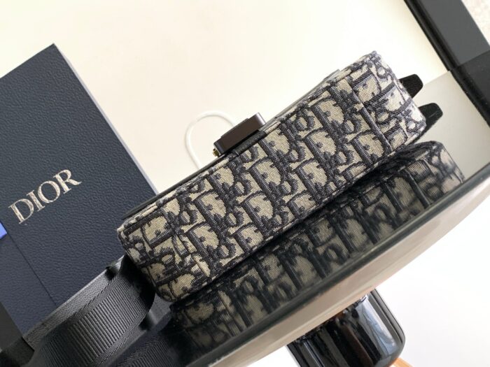 Borsa Dior elegante con packaging blu su superficie riflettente di alta moda.