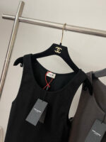 Vestito nero Chanel in esposizione elegante, con dettagli minimalisti e logo iconico.