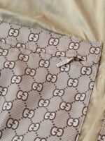 Interno di borsa Gucci con logo Double G e zip, eleganza e qualità luxury.