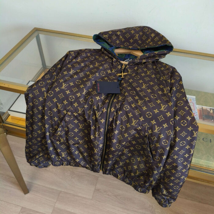 Giacca puffer di lusso con logo dorato, cappuccio colorato e design elegante.