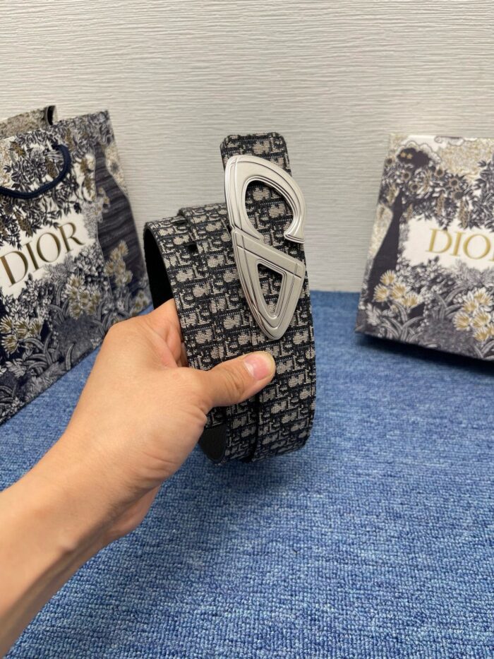 Cintura Dior di lusso con fibbia elegante, tra shopping bags raffinati e dettagli di stile.