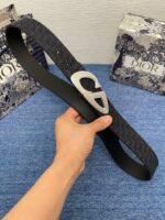 Cintura Dior nera con fibbia a forma di cuore e confezione elegante.