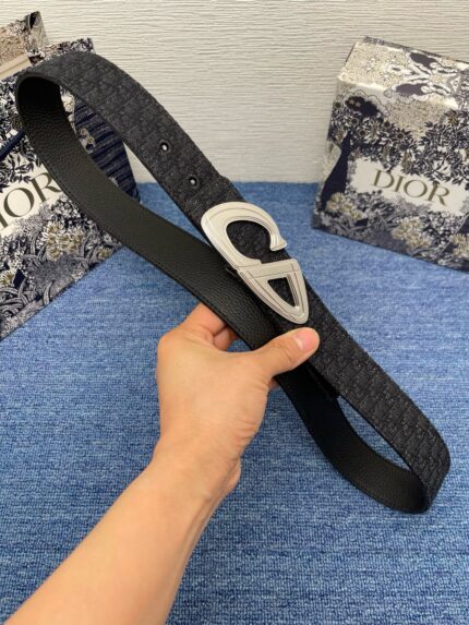 Cintura Dior nera con fibbia a forma di cuore e confezione elegante.