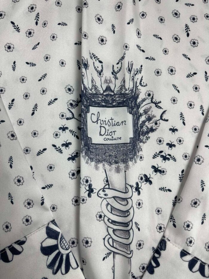 Tessuto Dior con motivi floreali delicati e dettagli eleganti, perfetto per capi di alta moda.
