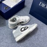 Sneaker Dior grigio di lusso con logo moderno e bag blu elegante, stile e raffinatezza.