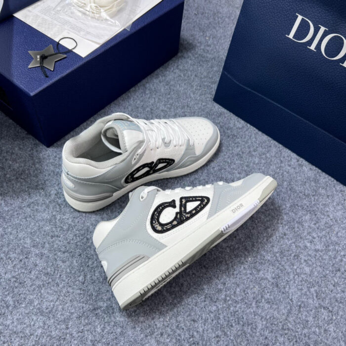 Sneaker Dior grigio di lusso con logo moderno e bag blu elegante, stile e raffinatezza.