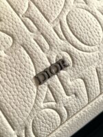 Pelle Dior embossata crema con logo argentato e dettagli eleganti di alta moda.
