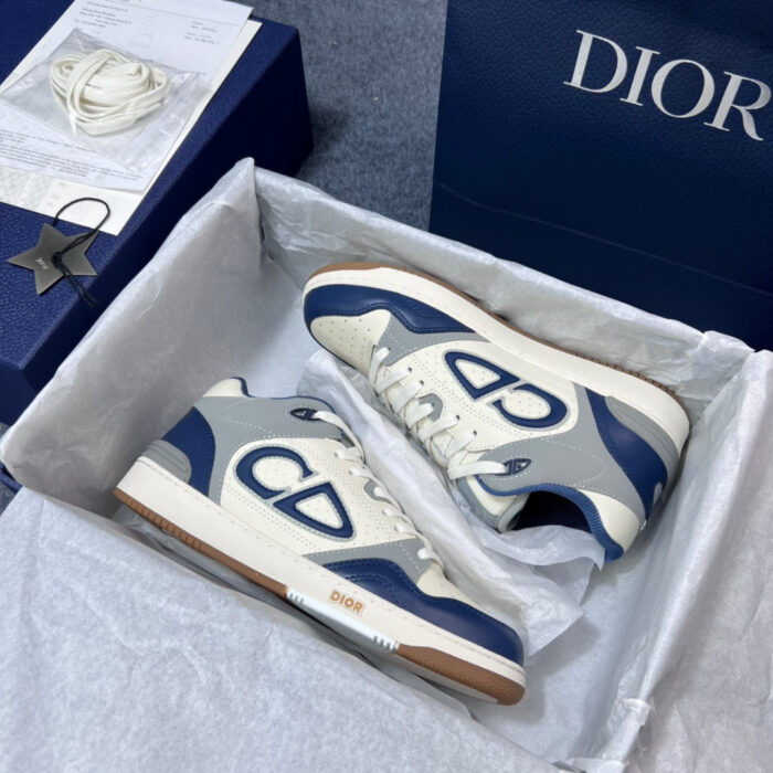 Sneakers Dior di lusso, stile elegante inside una scatola raffinata con dettagli blu e bianco.