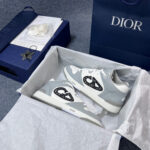 Sneakers Dior bianche e grigio in confezione di lusso con logo e dettaglio star.