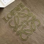 Ricamo Loewe verde oliva su tessuto di lusso, dettagli raffinati e artigianali.